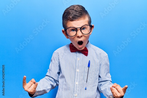 Cuadro en lienzo Cute blond kid wearing nerd bow tie and glasses shouting with crazy expression doing rock symbol with hands up