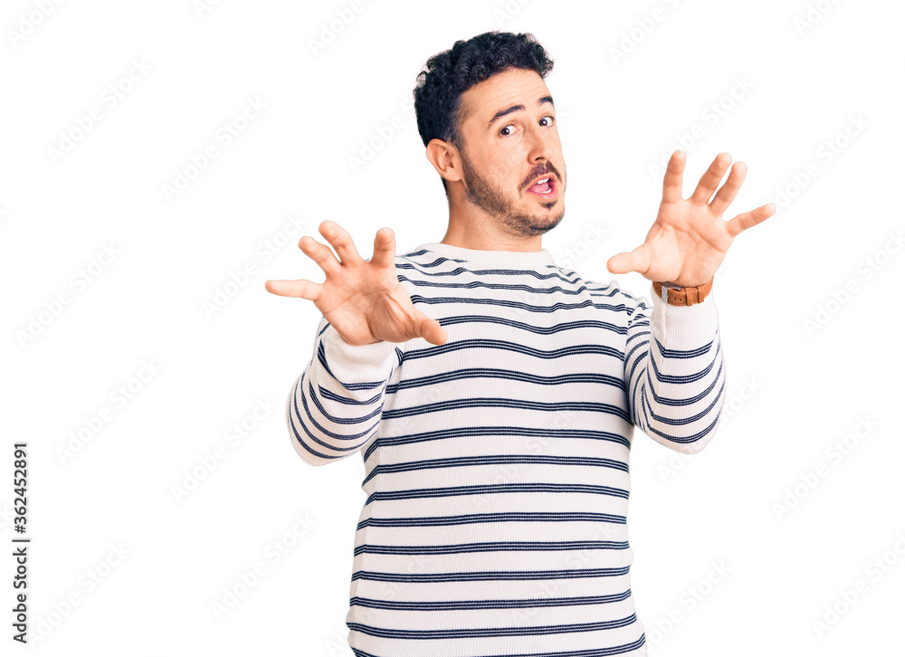Young hispanic man wearing casual clothes afraid and terrified with fear expression stop gesture with hands, shouting in shock. panic concept. Young hispanic man wearing casual clothes afraid and terrified with fear expression stop gesture with hands, shouting in shock. panic concept.