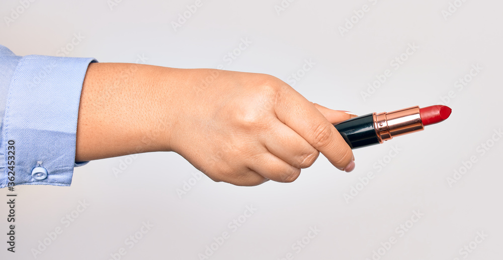 Hand of caucasian young woman holding red lipstick over isolated white background Hand of caucasian young woman holding red lipstick over isolated white background