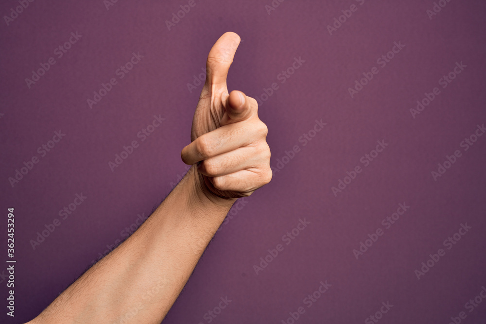 Hand of caucasian young man showing fingers over isolated purple background pointing forefinger to the camera, choosing and indicating towards direction