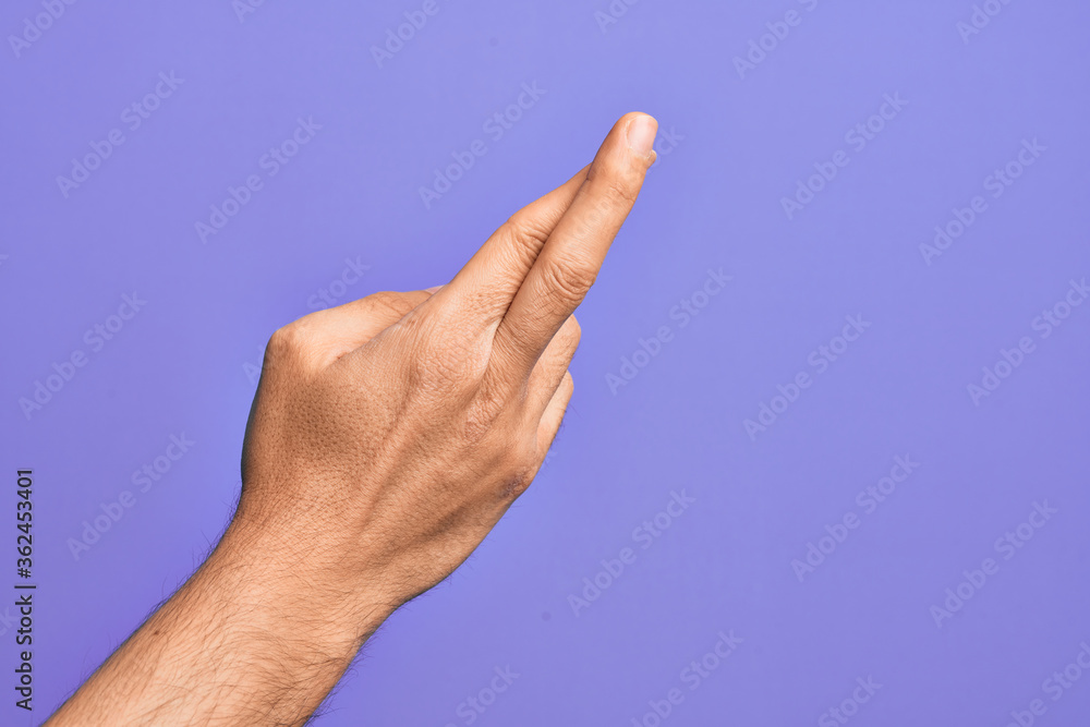 Hand of caucasian young man showing fingers over isolated purple background gesturing fingers crossed, superstition and lucky gesture, lucky and hope expression Hand of caucasian young man showing fingers over isolated purple background gesturing fingers crossed, superstition and lucky gesture, lucky and hope expression