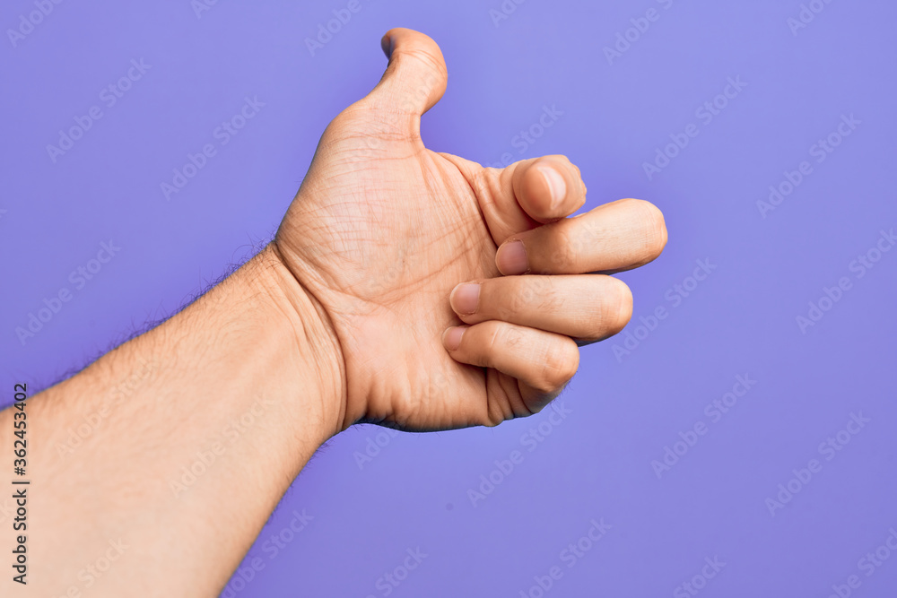 Hand of caucasian young man showing fingers over isolated purple background pointing forefinger to the camera, choosing and indicating towards direction