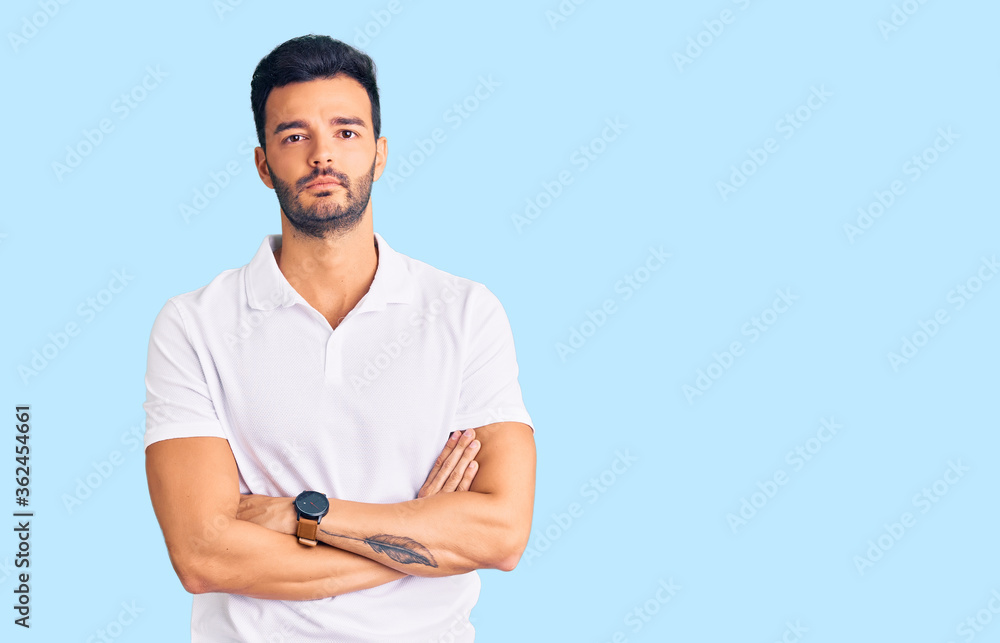 Young handsome hispanic man wearing casual clothes skeptic and nervous, disapproving expression on face with crossed arms. negative person. Young handsome hispanic man wearing casual clothes skeptic and nervous, disapproving expression on face with crossed arms. negative person.
