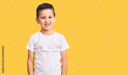Little cute boy kid wearing casual white tshirt looking positive and happy standing and smiling with a confident smile showing teeth © Krakenimages.com