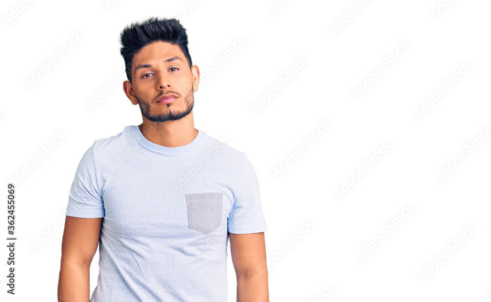 Fototapeta premium Handsome latin american young man wearing casual clothes relaxed with serious expression on face. simple and natural looking at the camera.