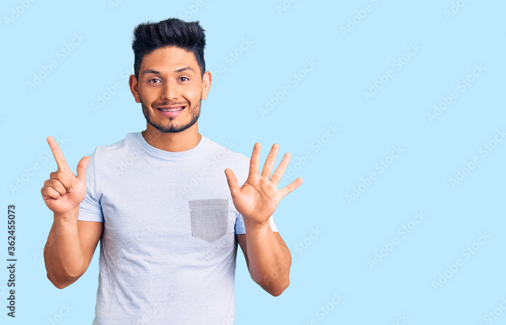Handsome latin american young man wearing casual clothes showing and pointing up with fingers number seven while smiling confident and happy. Handsome latin american young man wearing casual clothes showing and pointing up with fingers number seven while smiling confident and happy.