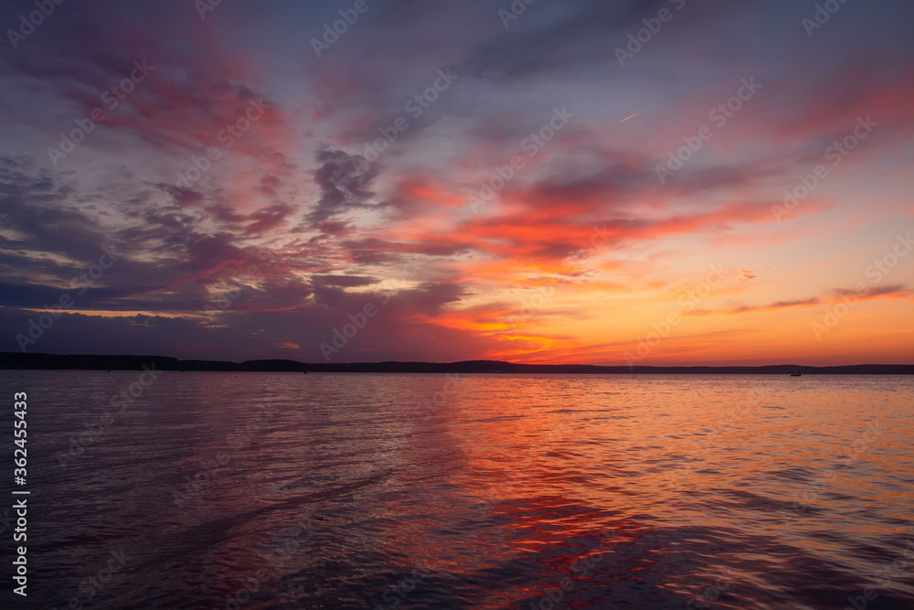 Summer evening. Amazing scenery. Colorful sky after sunset above lake.