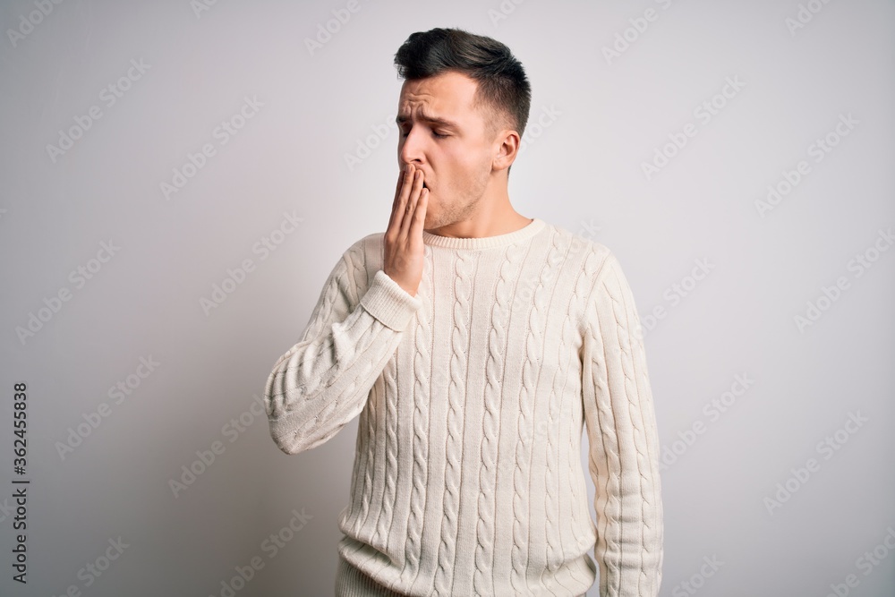 Young handsome caucasian man wearing casual winter sweater over white isolated background bored yawning tired covering mouth with hand. Restless and sleepiness. Young handsome caucasian man wearing casual winter sweater over white isolated background bored yawning tired covering mouth with hand. Restless and sleepiness.