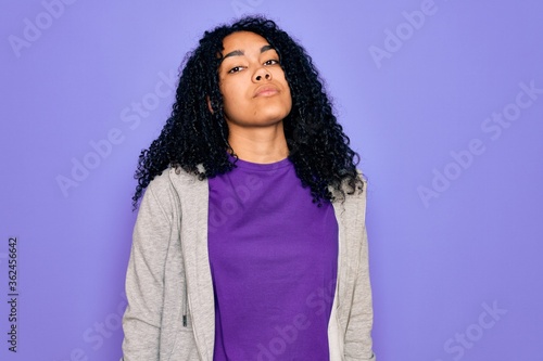 Young african american sporty woman wearing casual sweatshirt over purple background Relaxed with serious expression on face. Simple and natural looking at the camera. © Krakenimages.com