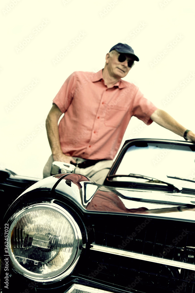 A man with sunglass standing near a car A man with sunglass standing near a car