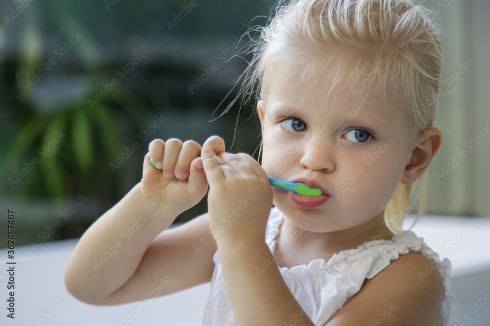 Adorable 3 years old girl brushing her teeth in bathroom. Adorable 3 years old girl brushing her teeth in bathroom.