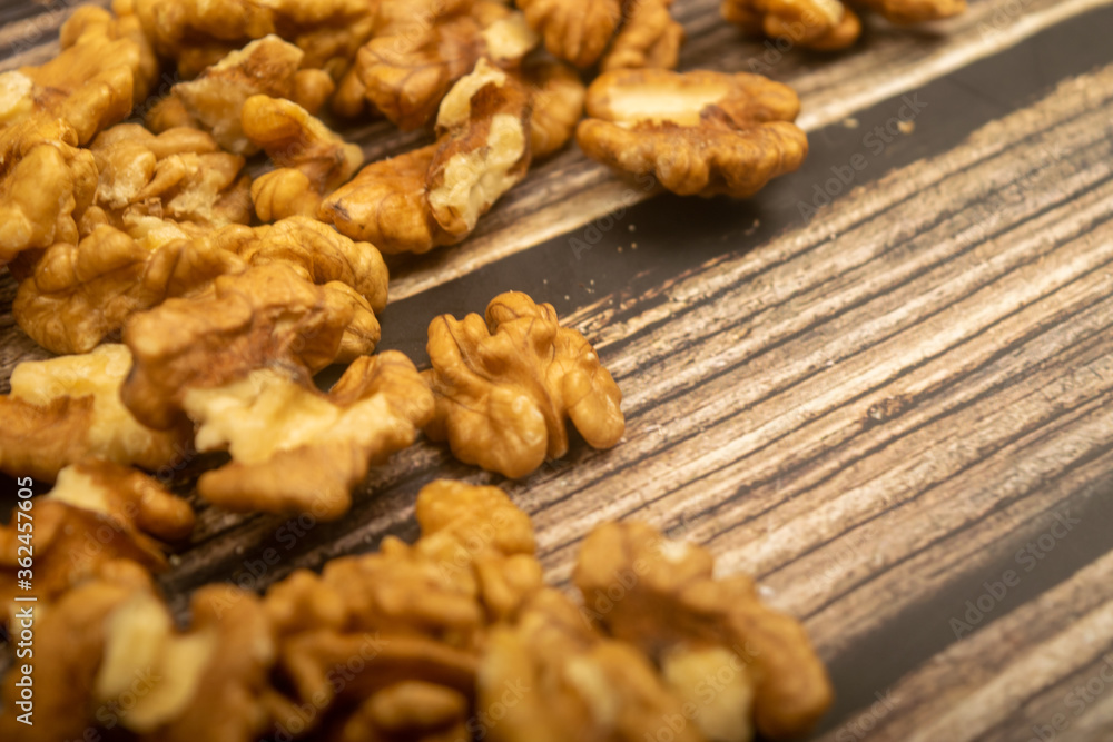Peeled walnuts scattered on a wooden table. Healthy diet. Fitness diet. Close up. Peeled walnuts scattered on a wooden table. Healthy diet. Fitness diet. Close up.