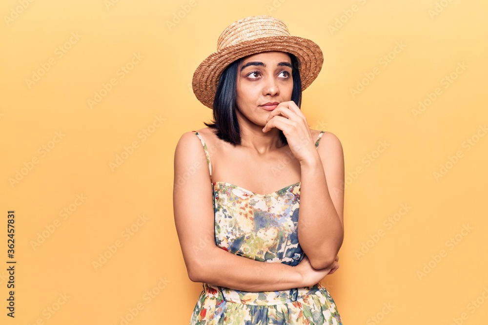 Young beautiful latin woman wearing summer hat looking stressed and nervous with hands on mouth biting nails. anxiety problem. Young beautiful latin woman wearing summer hat looking stressed and nervous with hands on mouth biting nails. anxiety problem.