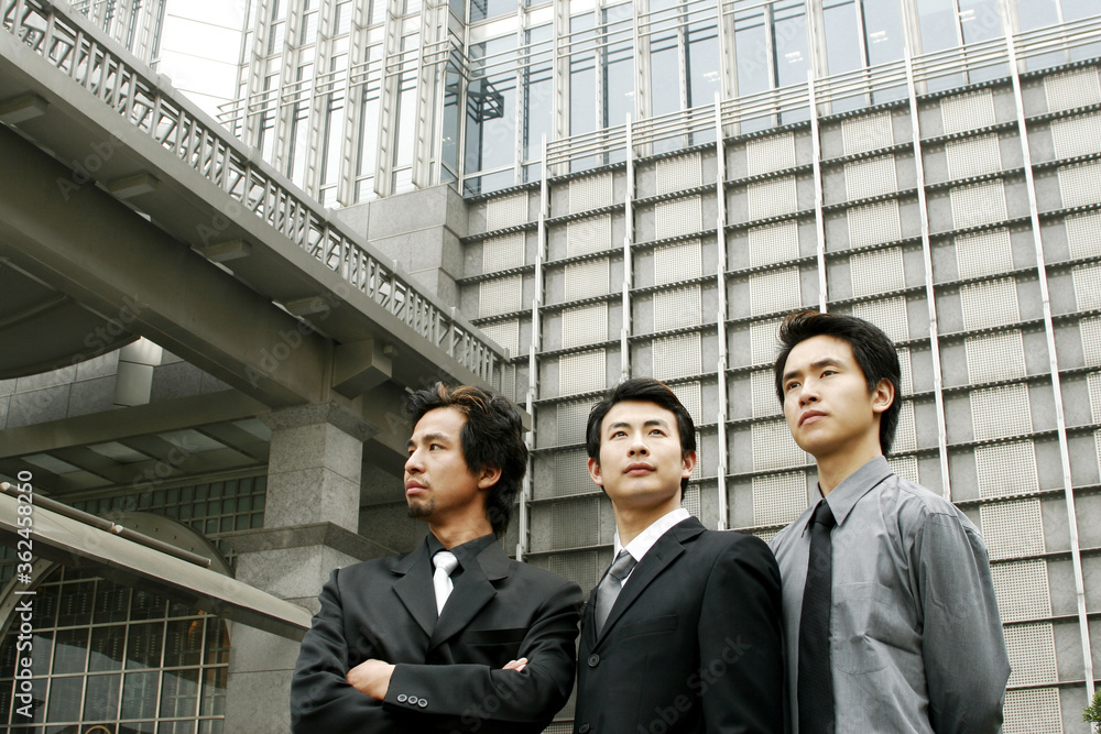Three businessmen standing in front of the building Three businessmen standing in front of the building