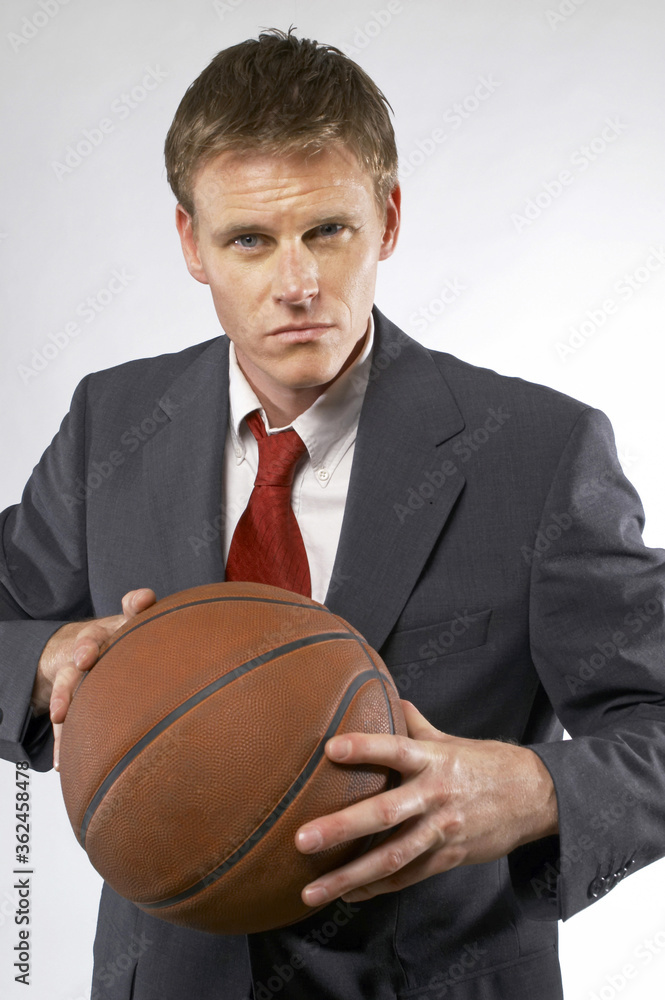 Man in business suit holding a basketball