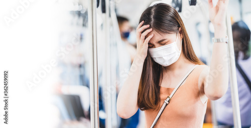 Obraz na płótnie Young Asian woman passenger wearing surgical mask and Having a headache in subway train when traveling in big city at Covid19 outbreak, Infection and Pandemic,new normal and illness prevention concept w salonie