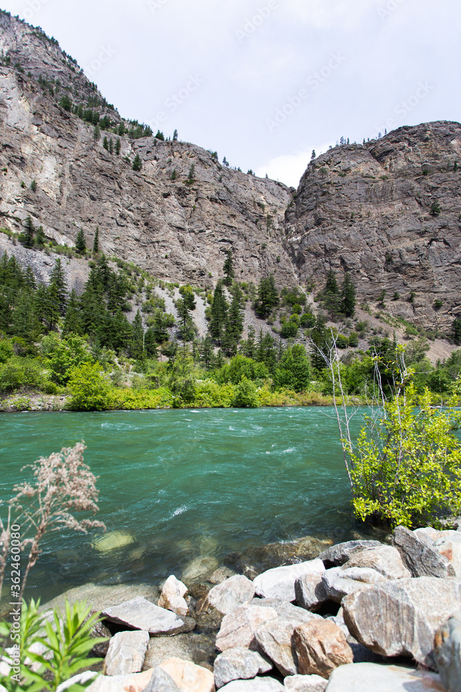 turquoise river with a tall cliff in summer