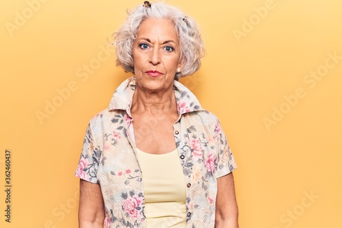 Senior grey-haired woman wearing casual clothes with serious expression on face. simple and natural looking at the camera.