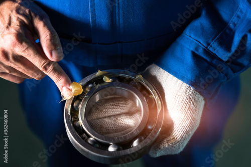 Mechanic is putting yellow grease in the into bearing, engineering and industrial concept.