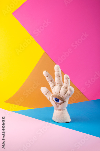 Protective amulet in the shape of an open palm and eye made of felted vul on a colored background photo