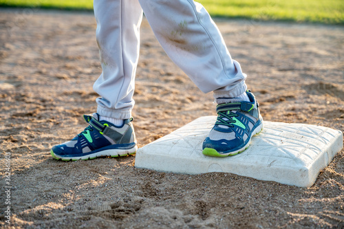 Photography Youth baseball with a runner safe on base with a left foot tagged