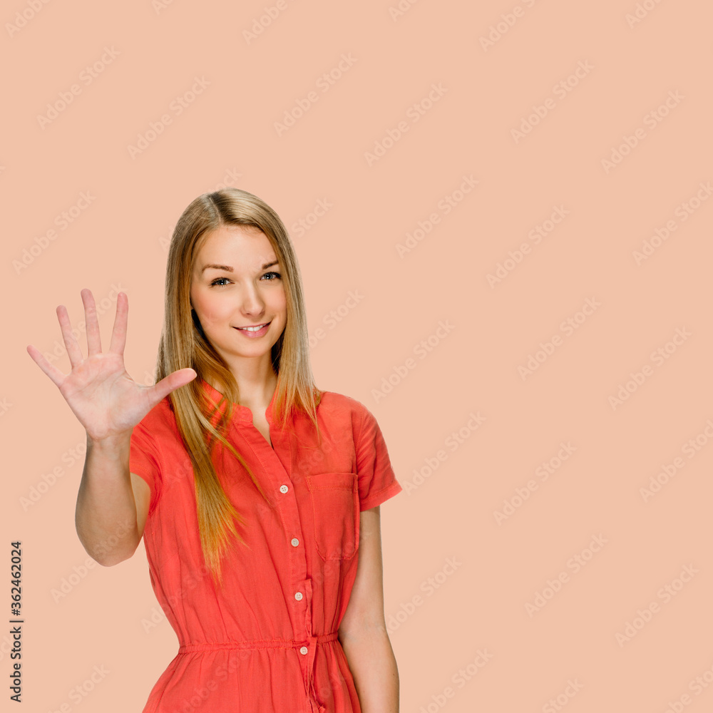 Pretty young girl counting five with fingers on salmon shade red background Pretty young girl counting five with fingers on salmon shade red background