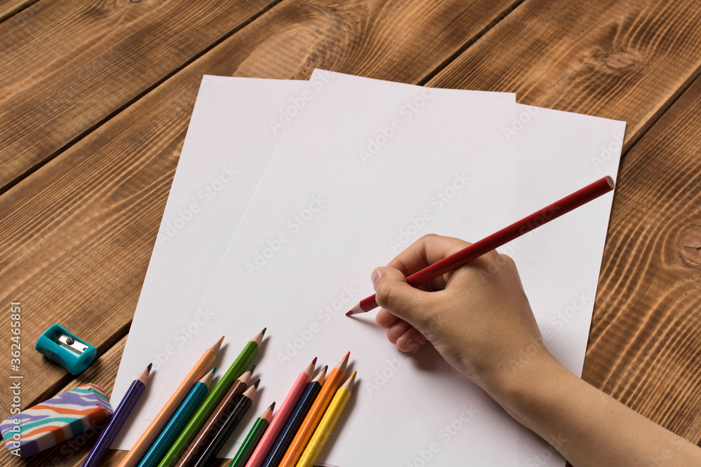 The girl draws with colored pencils. Close up. The girl draws with colored pencils. Close up.