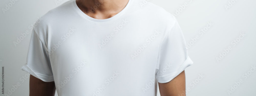 man in white blank t-shirt, empty wall, studio portrait. Wide screen, panoramic