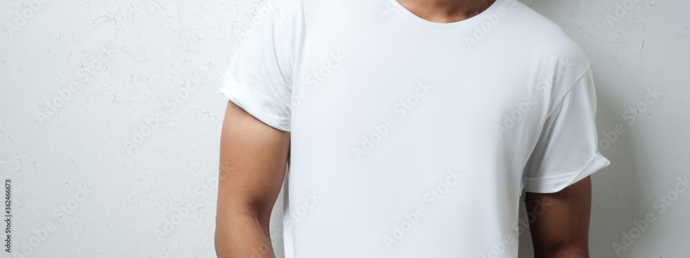 man in white blank t-shirt, grunge wall, studio close-up. Wide screen, panoramic man in white blank t-shirt, grunge wall, studio close-up. Wide screen, panoramic