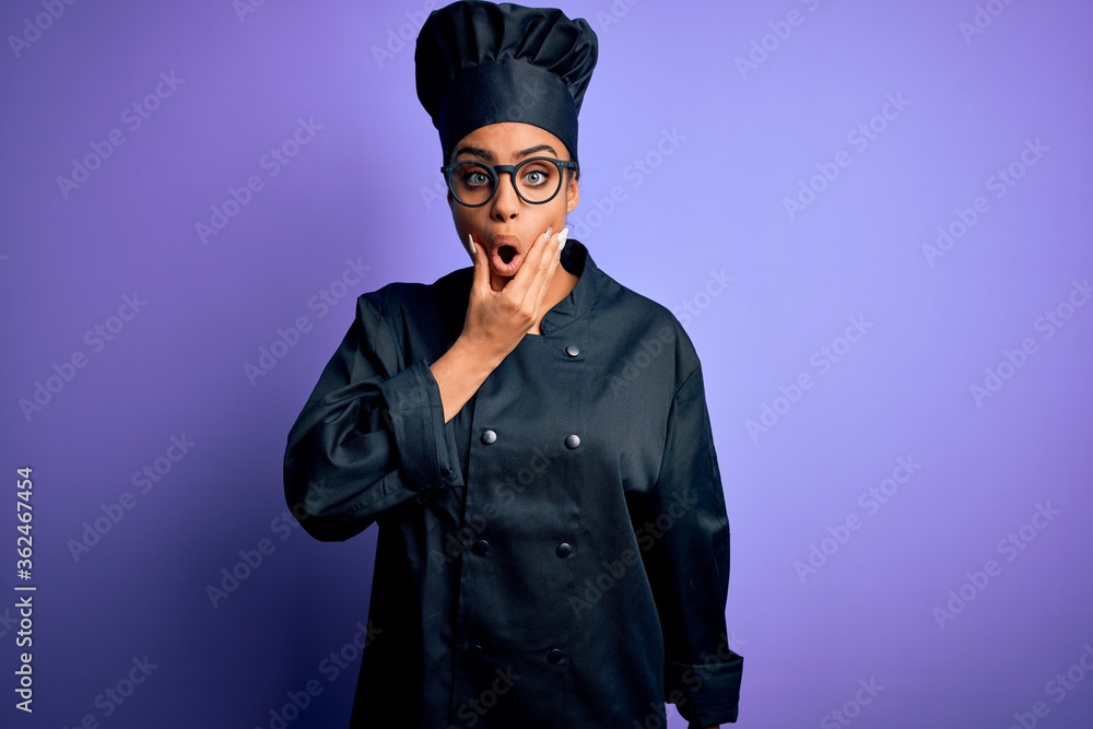 Young african american chef girl wearing cooker uniform and hat over purple background Looking fascinated with disbelief, surprise and amazed expression with hands on chin Young african american chef girl wearing cooker uniform and hat over purple background Looking fascinated with disbelief, surprise and amazed expression with hands on chin