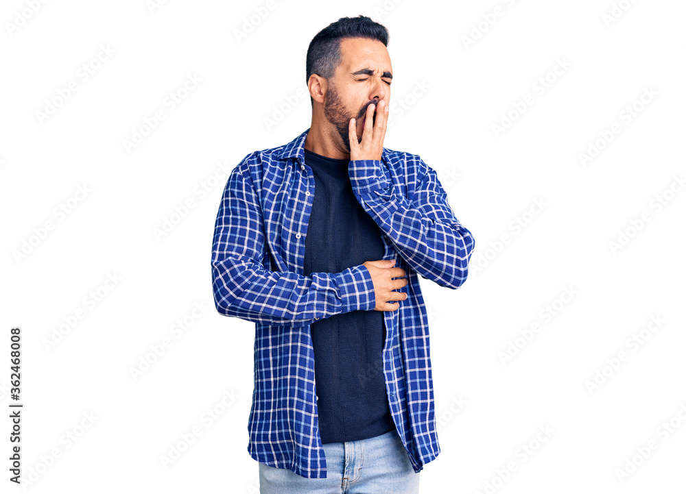 Young hispanic man wearing casual clothes bored yawning tired covering mouth with hand. restless and sleepiness. Young hispanic man wearing casual clothes bored yawning tired covering mouth with hand. restless and sleepiness.