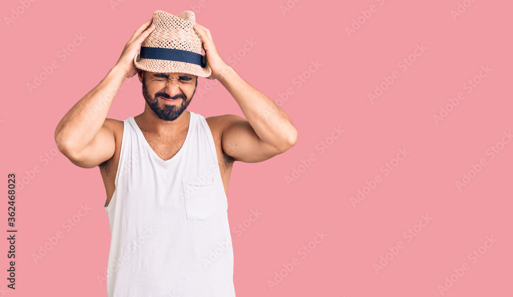 Young hispanic man wearing casual summer hat suffering from headache desperate and stressed because pain and migraine. hands on head. Young hispanic man wearing casual summer hat suffering from headache desperate and stressed because pain and migraine. hands on head.