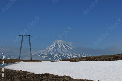A high-voltage transmission lines along the Vilyuchinsky pass (Vilyuchinsky volcano is visible on the background), Kamchatka Peninsula, Far East Russia