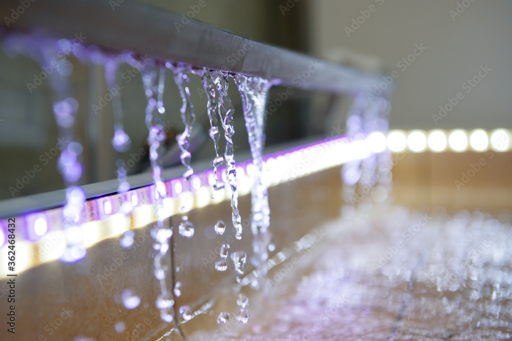 Water is drained from the tray to the floor of the shower. Multi-colored LED backlight - obrazy, fototapety, plakaty 