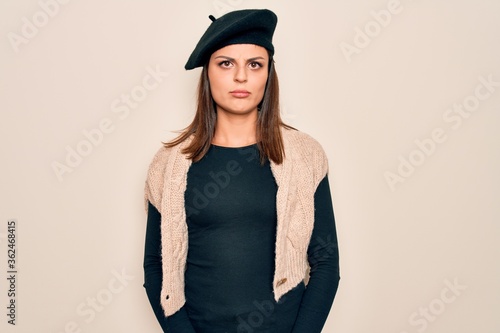 Young beautiful brunette woman wearing casual french beret over white background depressed and worry for distress, crying angry and afraid. Sad expression.