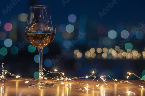A glass of Rose wine with colorful city bokeh light background.