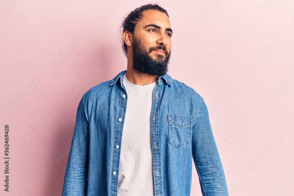 Obraz premium Young arab man wearing casual clothes looking to side, relax profile pose with natural face and confident smile.