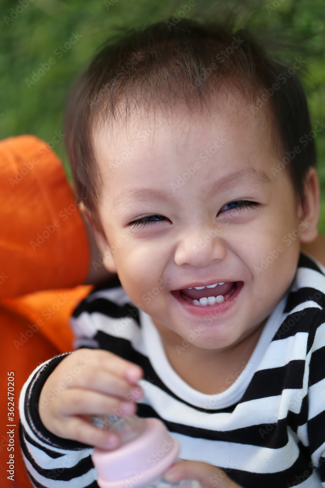 An Asian boy is laughing happily.