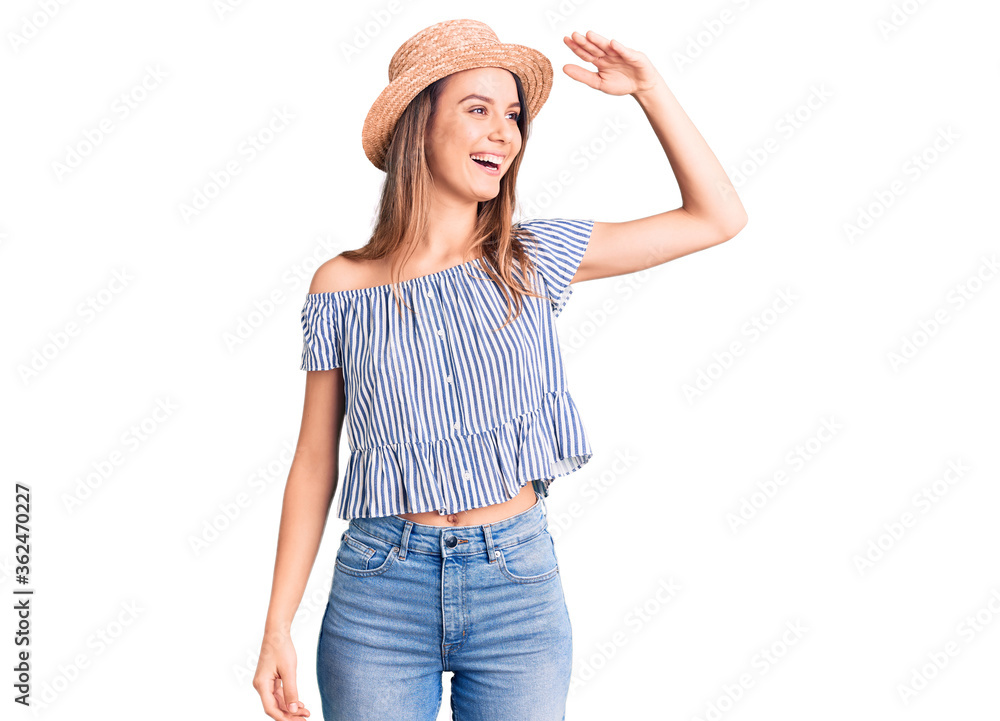 Young beautiful girl wearing hat and t shirt very happy and smiling looking far away with hand over head. searching concept. Young beautiful girl wearing hat and t shirt very happy and smiling looking far away with hand over head. searching concept.
