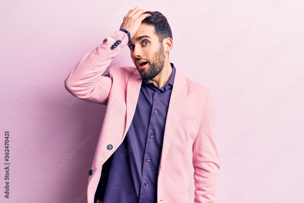 Young handsome man with beard wearing elegant jacket surprised with hand on head for mistake, remember error. forgot, bad memory concept. Young handsome man with beard wearing elegant jacket surprised with hand on head for mistake, remember error. forgot, bad memory concept.
