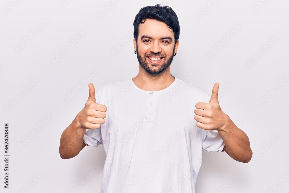 Young hispanic man wearing casual clothes success sign doing positive gesture with hand, thumbs up smiling and happy. cheerful expression and winner gesture. Young hispanic man wearing casual clothes success sign doing positive gesture with hand, thumbs up smiling and happy. cheerful expression and winner gesture.