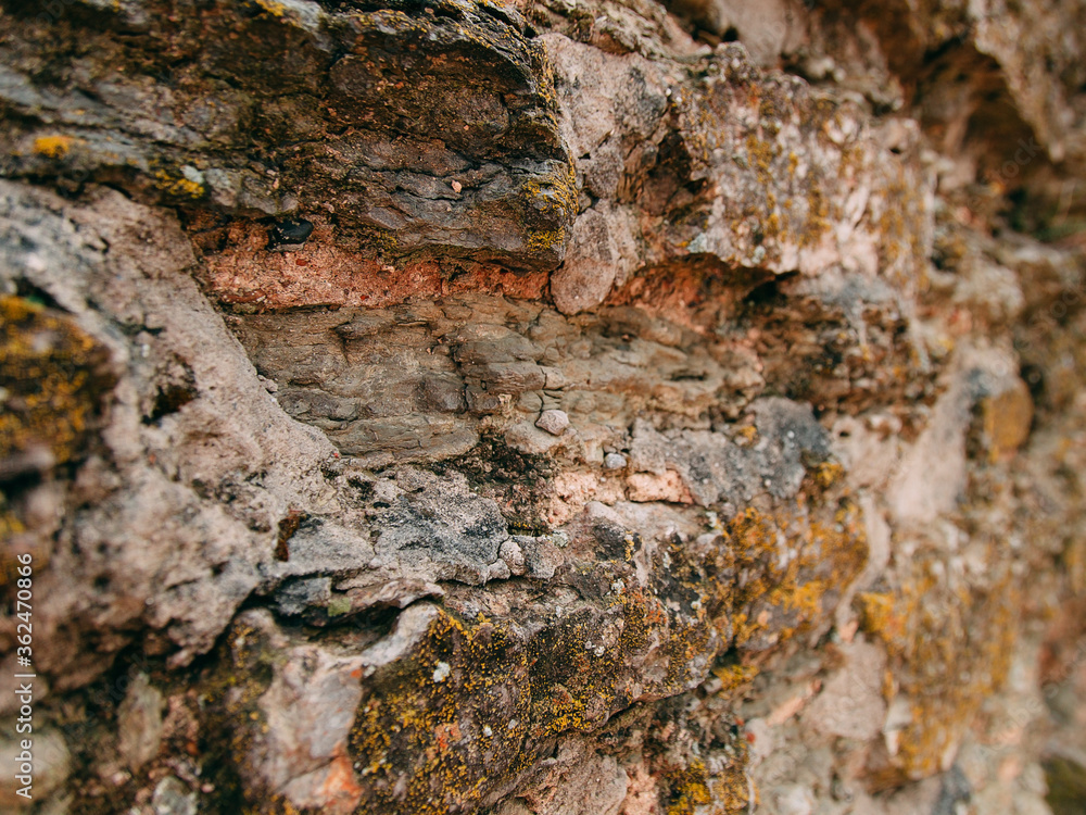 An old medieval stone wall, grass and moss on it. Wallpaper, natural background, copy space, soft focus. An old medieval stone wall, grass and moss on it. Wallpaper, natural background, copy space, soft focus.