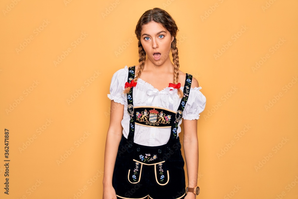 Young beautiful blonde german woman with blue eyes wearing traditional octoberfest dress In shock face, looking skeptical and sarcastic, surprised with open mouth Young beautiful blonde german woman with blue eyes wearing traditional octoberfest dress In shock face, looking skeptical and sarcastic, surprised with open mouth