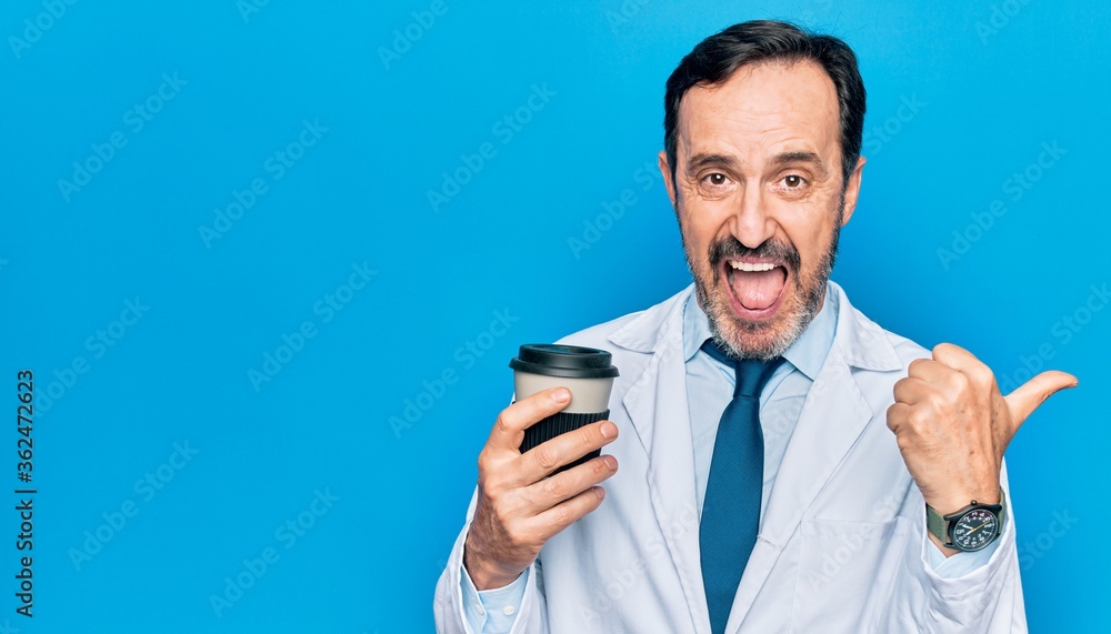 Middle age handsome doctor man wearing coat drinking cup of takeaway coffee pointing thumb up to the side smiling happy with open mouth Middle age handsome doctor man wearing coat drinking cup of takeaway coffee pointing thumb up to the side smiling happy with open mouth