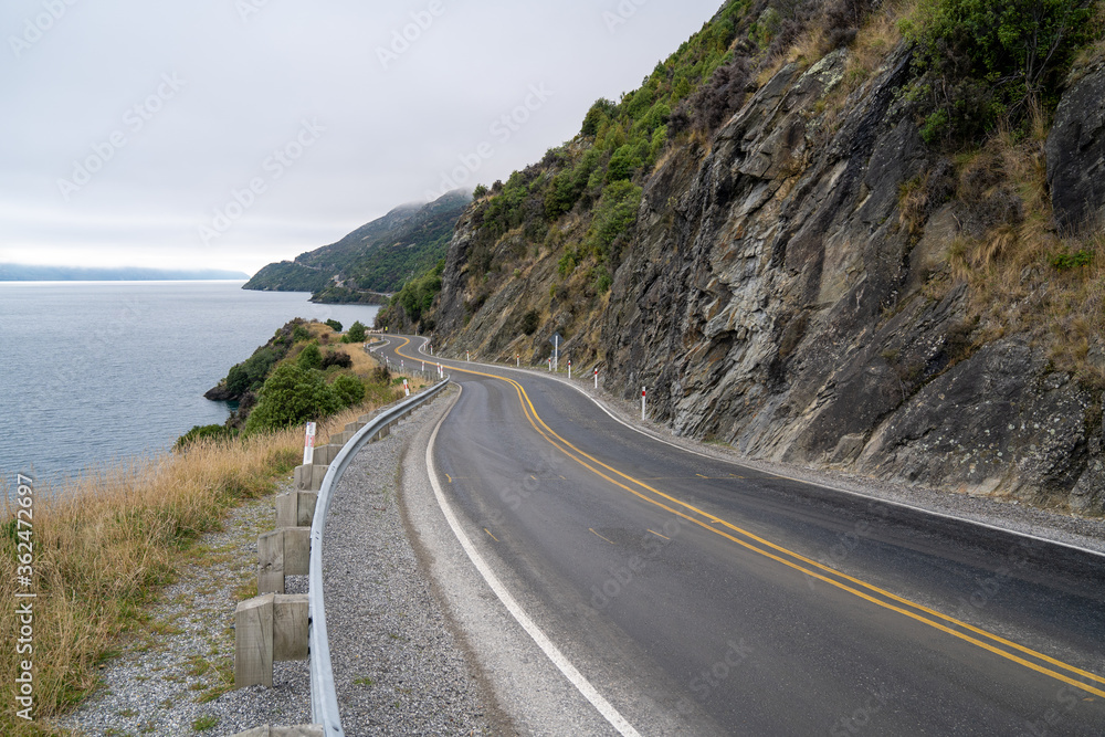 Beautiful road with cloudy sky along Lake Wakatipu, Queenstown, New Zealand.