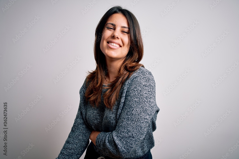 Young beautiful brunette woman smiling happy and confident. Standing with smile on face wearing casual sweater over isolated white background Young beautiful brunette woman smiling happy and confident. Standing with smile on face wearing casual sweater over isolated white background