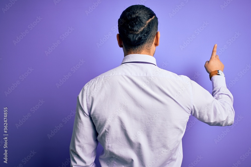 Young brazilian businessman wearing elegant tie standing over isolated purple background Posing backwards pointing ahead with finger hand Young brazilian businessman wearing elegant tie standing over isolated purple background Posing backwards pointing ahead with finger hand