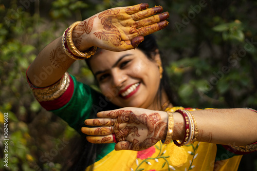 Indian woman with smiling face showing palms painted with mahendi or myrtle photo