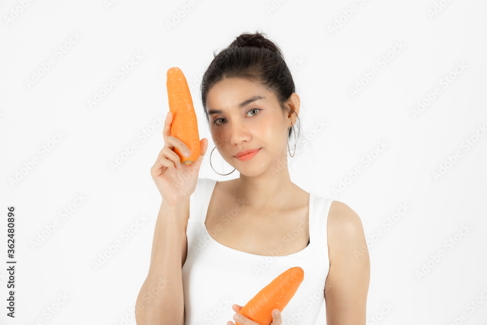Healthy young Asian woman holding carrot over white isolated background. Vegetarian, Healthy lifestyle, Fitness and health care concept. Healthy young Asian woman holding carrot over white isolated background. Vegetarian, Healthy lifestyle, Fitness and health care concept.
