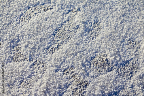 Snow or ice texture or background outdoors in a winter day. Nature landscape with frozen water on a lake or river in the cold and sun.